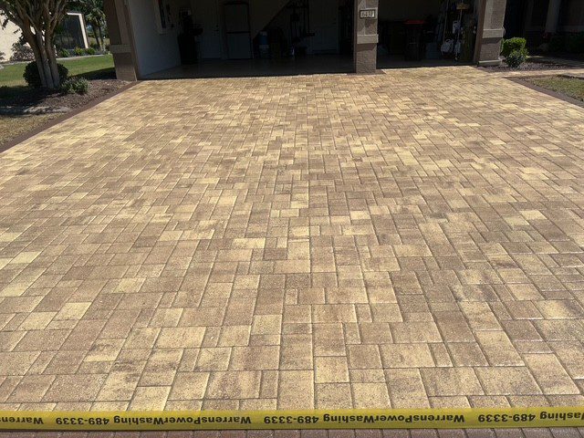 A paved brick driveway with a yellow measuring tape at the bottom.