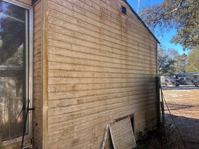 Dirty beige vinyl siding with leaning screen